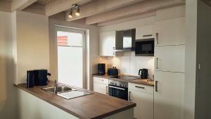 a kitchen with white cabinets and a counter top at Ferienhaus Klabautermann 53 - Nordhorn in Nordhorn