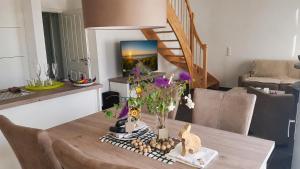 a dining room table with a vase of flowers on it at Ferienhaus Klabautermann 53 - Nordhorn in Nordhorn
