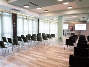 a conference room with chairs and a podium at Mercure Bologna Centro in Bologna