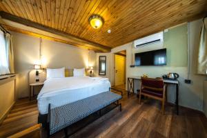 a bedroom with a bed and a desk and a tv at imera hotel in Edirne