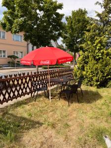 a table and chairs under a red umbrella at Gästezimmer in Hafennähe in Waren