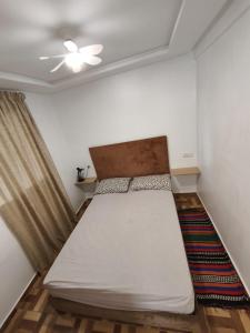 a small bedroom with a bed and a ceiling at Younes résidence 2 in Asilah