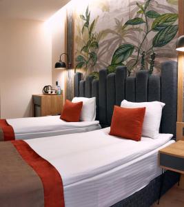 two beds in a room with a painting on the wall at BURSA KOZA HOTEL in Bursa