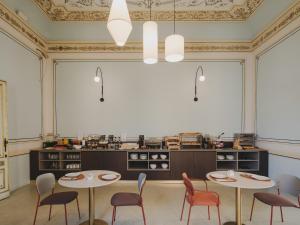 a room with two tables and chairs and a kitchen at BYPILLOW Grand Central in Padova