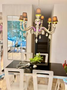 a dining room with a table and a chandelier at ENKLAWA IMPERIUM- DOM WAKACYJNY-APARTAMENTY NAD JEZIOREM- 20 km od TORUNIA-PLAŻA,JACUZZI 