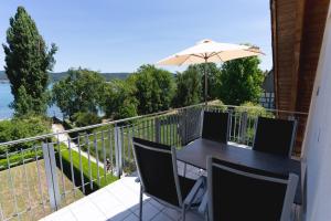 a balcony with an umbrella and a table and chairs at Ferienwohnung Ledergerber in Bodman-Ludwigshafen