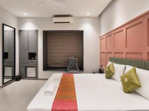 a bedroom with a large bed and a chair at The Bay Suites - Salt Lake in kolkata
