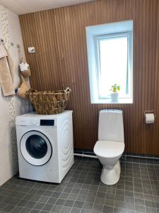 a bathroom with a washing machine and a toilet at Idyllic Charm- with a moat! in Kangasala +12 photos