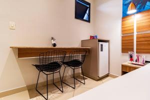 two black chairs sitting at a bar in a room at Soft Motel - USP in São Paulo