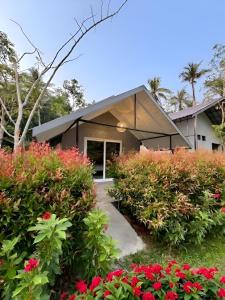 a house with red flowers in front of it at Zerohouse in Ban Bang Bao