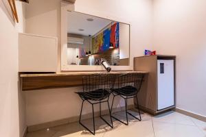 a kitchen with a sink and two stools at a counter at Soft Motel - USP in São Paulo +15 photos