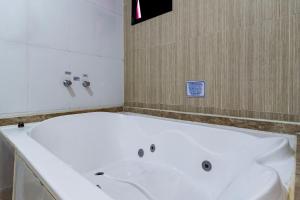 a large white bath tub in a bathroom at Soft Motel - USP in São Paulo