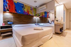 a bedroom with a large bed and a bathroom at Soft Motel - USP in São Paulo
