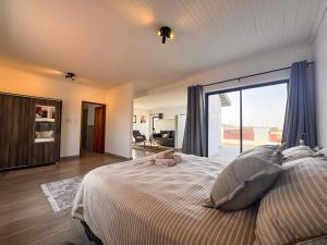 a bedroom with a large bed with a large window at House Sworyx in Walvis Bay +81 photos