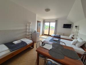 a room with two beds and a table and chairs at Malinowe Lato in Grzybowo
