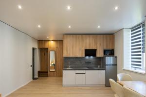 a kitchen with white cabinets and a refrigerator at MONTE GreeN in Polyana