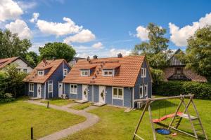 a house with a playground in a yard at Heideröschen Park Heideröschen 5c in Zingst