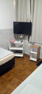 a bedroom with two beds and a flat screen tv at Pousada Popular in Barreiras