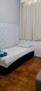 a futon bed in a room with a window at Pousada Popular in Barreiras +7 photos