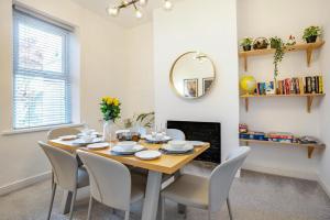 a dining room with a table and chairs and a mirror at 3 Bed in Cardiff oc-bow188 in Cardiff