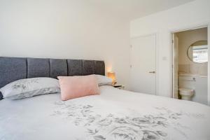 a white bed with a pink pillow on it at 3 Bed in Cardiff oc-bow188 in Cardiff