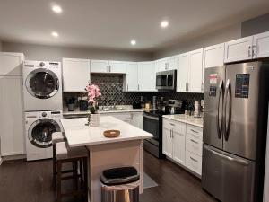 a kitchen with white cabinets and stainless steel appliances at Healing Haven King Bed Suite in Dallas
