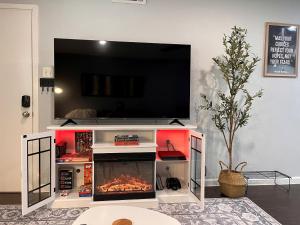 a tv on top of a entertainment center with a fireplace at Healing Haven King Bed Suite in Dallas