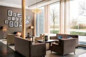 a living room with furniture and a large window at The Rilano Hotel Munich, Trademark Collection by Wyndham in Munich