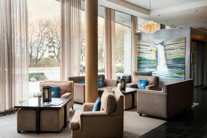 a lobby with couches and a painting of a waterfall at The Rilano Hotel Munich, Trademark Collection by Wyndham in Munich