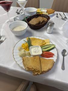 a white table with a plate of food on it at Beypil Place in Kochkorka