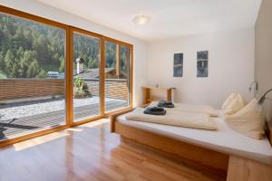 a bedroom with a bed and a large window at Pritscheshof Ferienwohnung Terrasse in Malles Venosta