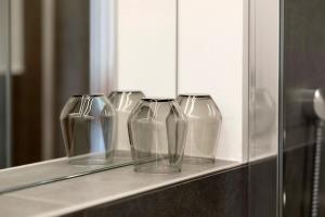 four clear glass vases sitting on a shelf at Pritscheshof Ferienwohnung Terrasse in Malles Venosta +29 photos