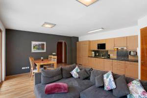 a living room with a gray couch and a table at Pritscheshof Ferienwohnung Terrasse in Malles Venosta