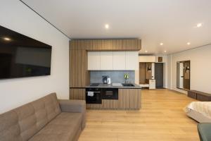a living room with a couch and a kitchen at MONTE GreeN in Polyana