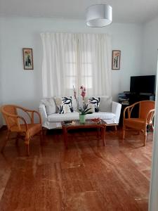 a living room with a white couch and two chairs at Asteri Hotel in Ornos