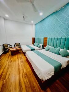 a room with two beds and a blue wall at Hotel Grand Royal Sandhu in Amritsar