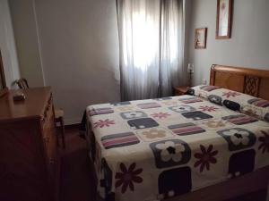 a bedroom with a bed with a quilt on it at Chipiona CERCA DE LA PLAYA in Chipiona +18 photos