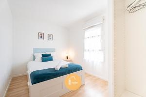 a white bedroom with a bed and a window at Duplex Le G - Reine des neiges 10 min Disney Paris in Montévrain