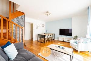 a living room with a couch and a table at Duplex Le G - Reine des neiges 10 min Disney Paris in Montévrain