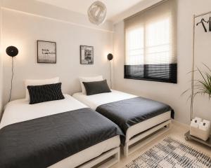 two beds in a small bedroom with a window at Yoonsul Gwangalli 3beds for 4guests in Suyŏng +7 photos
