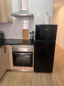 a kitchen with a black stove and a microwave at Casa Boho in Puerto de Mazarrón +20 photos