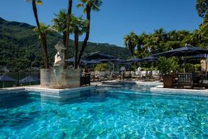 a pool at a resort with a statue in the water at Swiss Diamond Hotel & Spa in Morcote