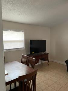 a living room with a flat screen tv and a table at Dolphin Cove in Sarasota