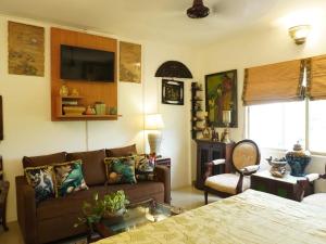a living room with a couch and a tv at On the House homestay in New Delhi