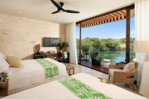 a bedroom with two beds and a view of the water at Rosewood Mayakoba in Playa del Carmen +291 photos