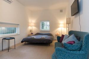 a living room with a bed and a blue couch at B&B Amsterdam West in Amsterdam