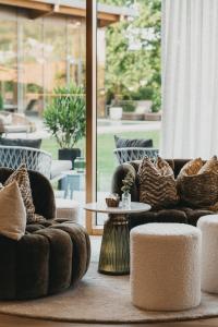 a living room with two couches and a table at Hotel Eibl-Brunner 4-Sterne-Superior in Frauenau