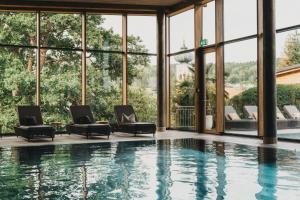 a house with a pool and windows at Hotel Eibl-Brunner 4-Sterne-Superior in Frauenau