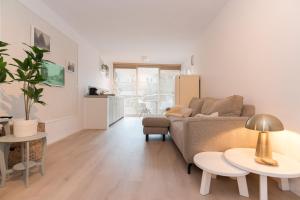 a living room with a couch and two tables at Studio Loet in Schagen +18 photos