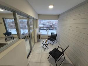 a room with two chairs and a table and windows at uriburu45 in Malargüe
